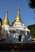 Myanmar - Inwa, white washed stupas with a Buddha statue protected by a naga where the road branch off to the teack monastery. 